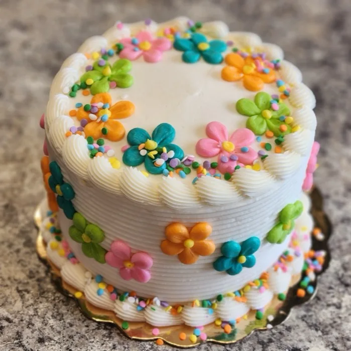 Cake decorated with colorful buttercream daisy flowers