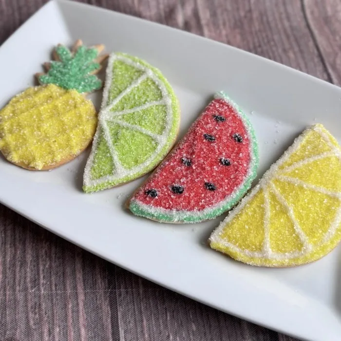 Decorated sugar cookies shaped like pineapple, lime, watermelon and lemon slices