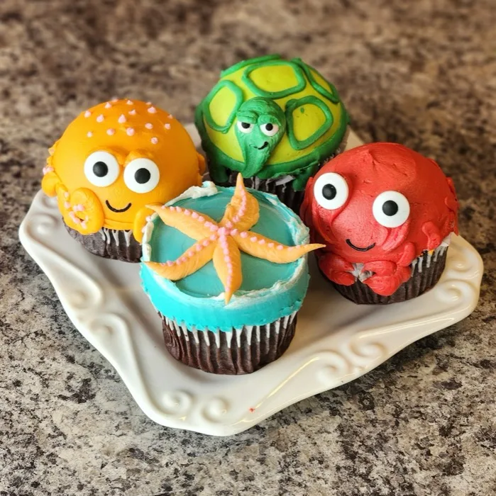 Cupcakes decorated with fondant sea creatures including an octopus, turtle, crab and starfish