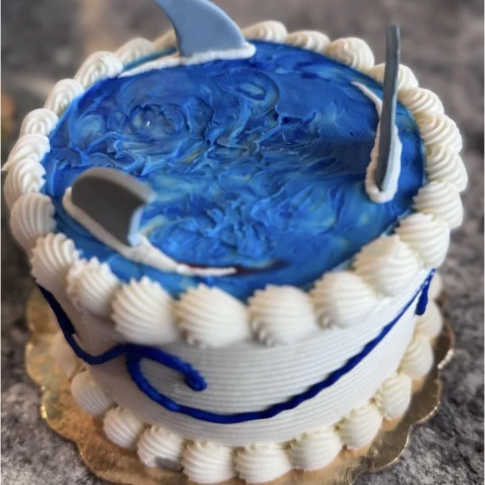 Blue ocean-swirl birthday cake with a fondant shark fin